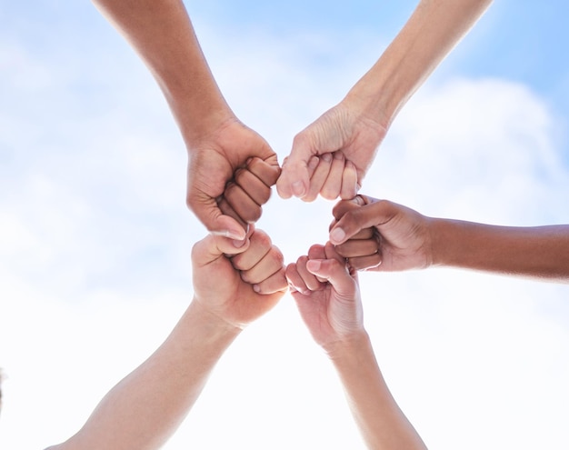 Believe in your power Shot of a group of unrecognizable people making a circle with their fists outside