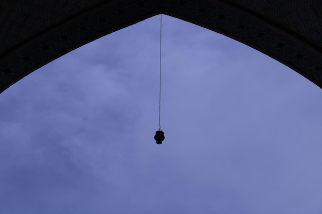 A bell hangs from a arch in the old city of kashgar.