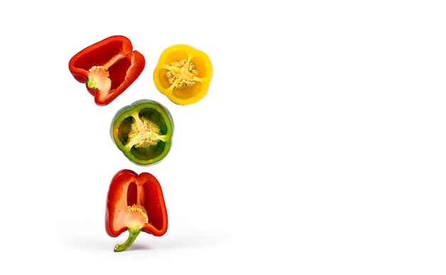 Bell peppers of red yellow and green color cut and fly isolated on a white background Copy space