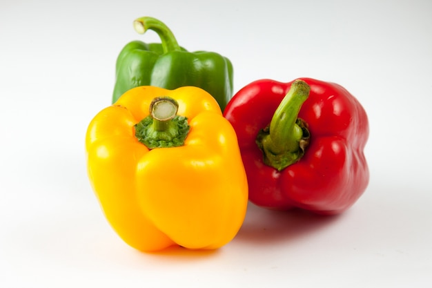 Photo bell peppers over white background, green, yellow and red fresh bell pepper