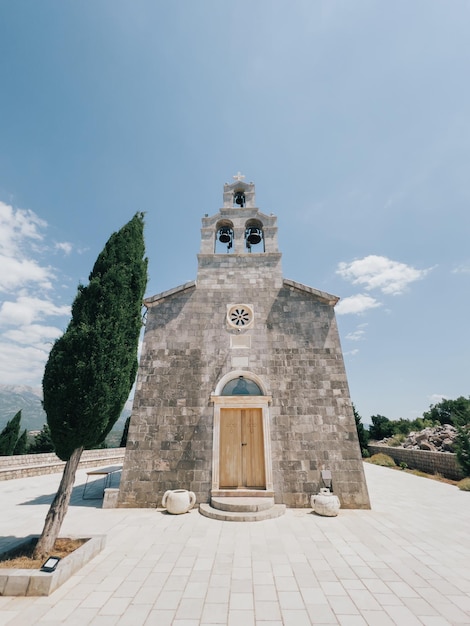 Bell tower of the church of the holy trinity on the background of a cloudy sky budva montenegro