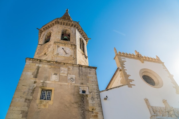 Bell tower of the st john baptist church and people in tomar portugal