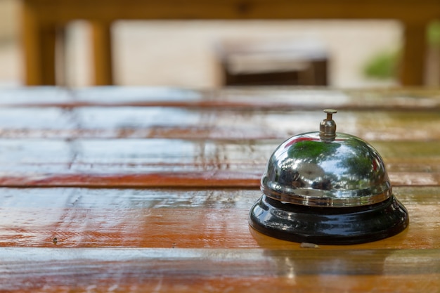 Bell on the wood table in restaurant with nature background