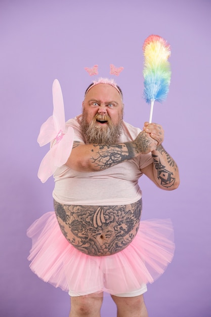 Bellicose obese person in fairy suit attacks with dust brush on purple background