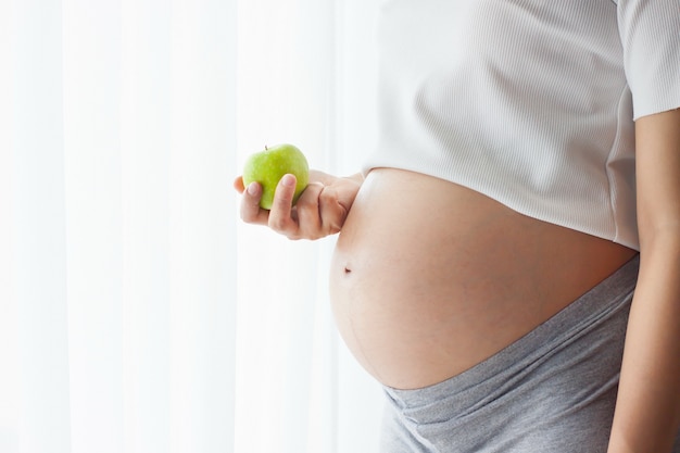 The belly asia pregnant woman with apple