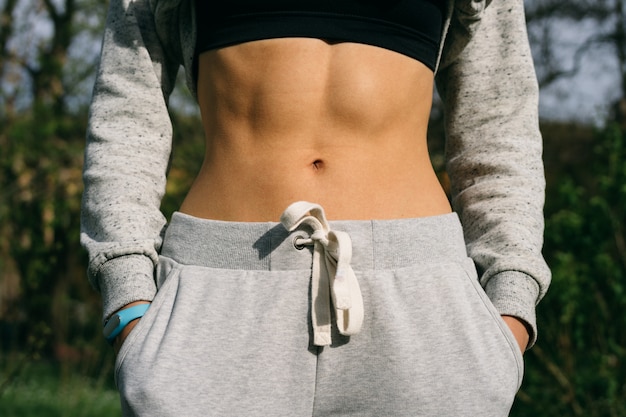 Belly athletic girl which is dressed in pants and a sports bra