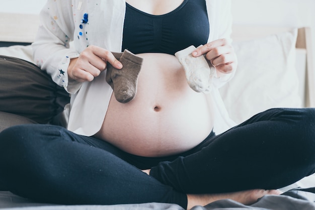 Фото Живот беременной женщины с руки выбора baby носки