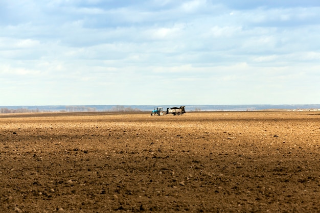 Bemesting van landbouwgrond landbouwgrond waarop tractor rijdt en bemest de grond Lente de tijd voor het planten