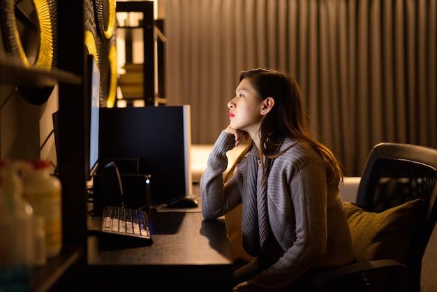 Benadrukt jonge Aziatische vrouw denken tijdens het werken vanuit huis