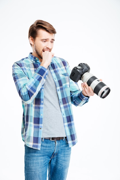 Benadrukt mannelijke fotograaf met fotocamera geïsoleerd op een witte achtergrond