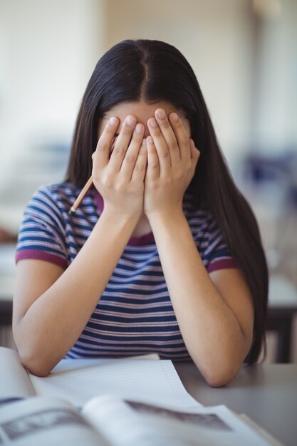 Benadrukt schoolmeisje dat haar gezicht in de klas behandelt