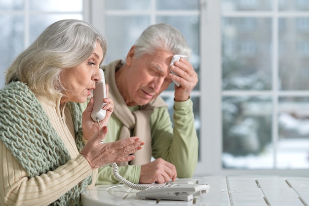 Benadrukt senior koppel, praten aan de telefoon