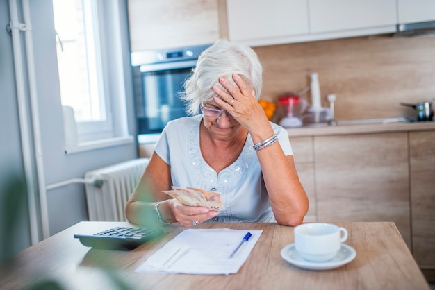 Benadrukt senior vrouw doet bank- en administratief werk thuis