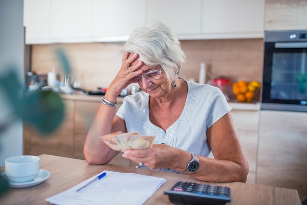 Benadrukt senior vrouw doet bank- en administratief werk thuis