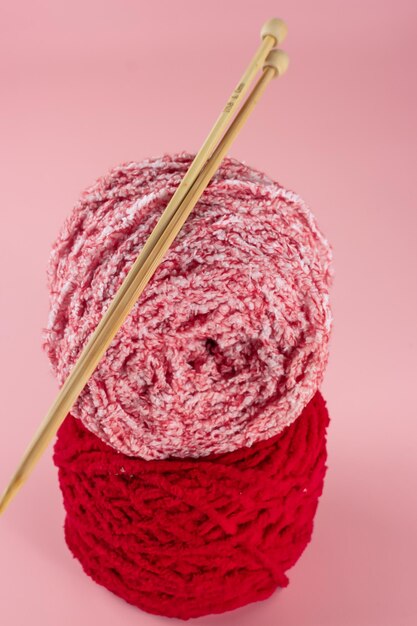 Benang rajut Knitting yarn balls and knitting needles on pink background Knitting concept