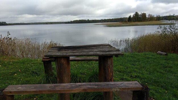 Photo bench by lake against sky