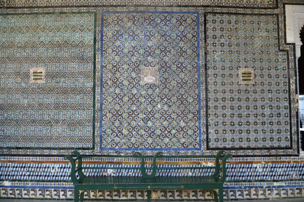 A bench in front of the tiled wall