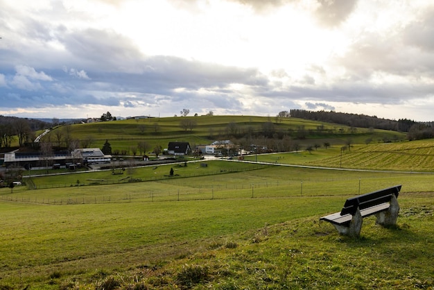 Bench on a hill near a village in sunlight