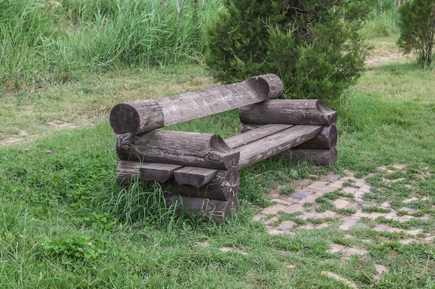 Bench made of logs in the park in summer