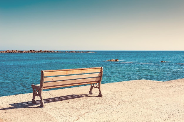 海岸のベンチ。サントリーニ島、ギリシャ。ヴィンテージフィルター、レトロ効果