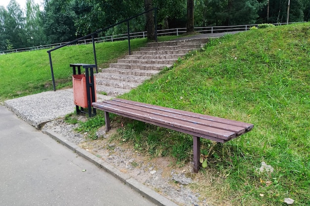 階段のそばの公園のベンチとゴミ箱