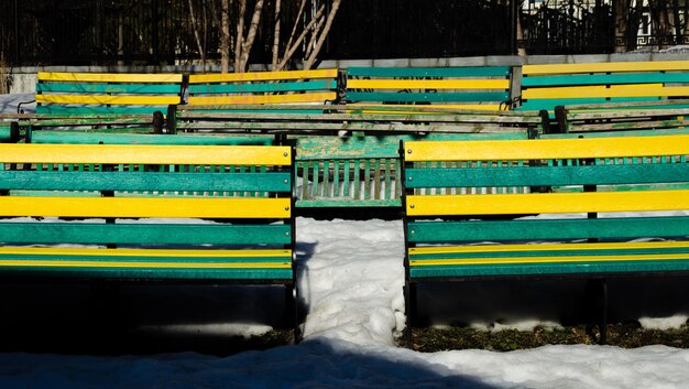 A bench with yellow and green paint that says " the word " on it.