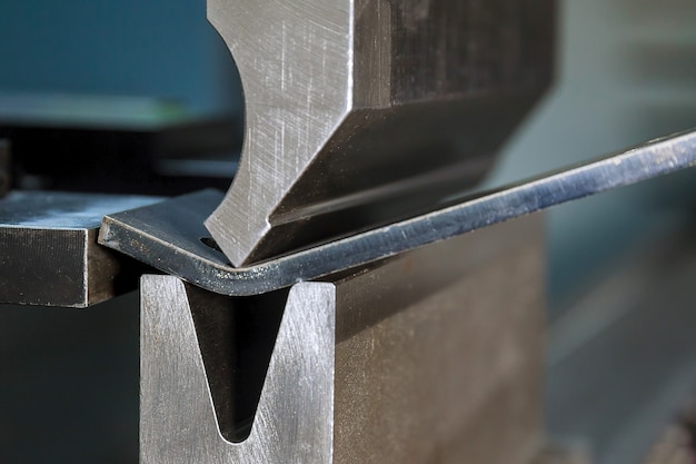 Photo bending sheet metal with a hydraulic machine at the factory. closeup.