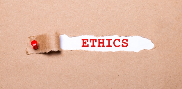 Beneath the torn strip of kraft paper attached with a red button is a white paper labeled ETHICS