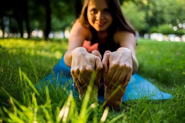 Benen en handen van een meisje close-up pilates doen op een mat in het park
