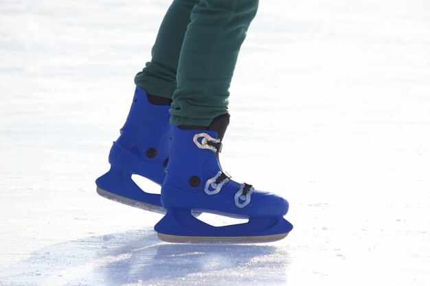 Benen in blauw schaatsen op de ijsbaan