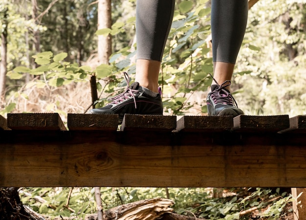 Benen in sneakers wandelaars voeten in sportschoenen tijdens wandelen trekking in natuur bos hout