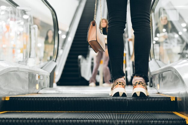 Benen staan op de roltrap van een winkelcentrum