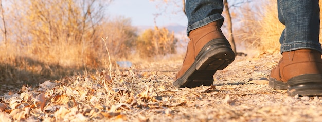 Benen van een man die buiten loopt. Lifestyle mode trendy stijl herfst seizoen natuur op achtergrond.