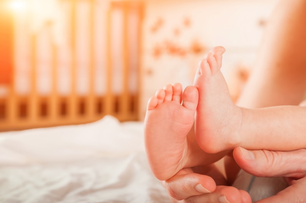 Benen van een pasgeborene in handenclose-up. Baby's voeten en kopieer de ruimte. Babyverzorging en koliek