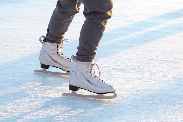 Benen van een schaatser op schaatsen op de straat ijsbaan