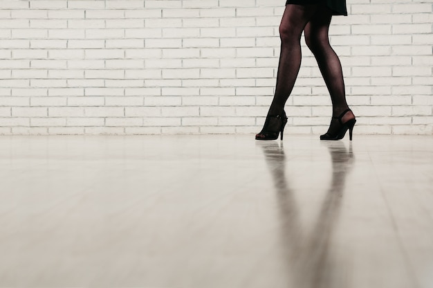 benen van een vrouw met zwarte panty's en schoenen met hoge hakken