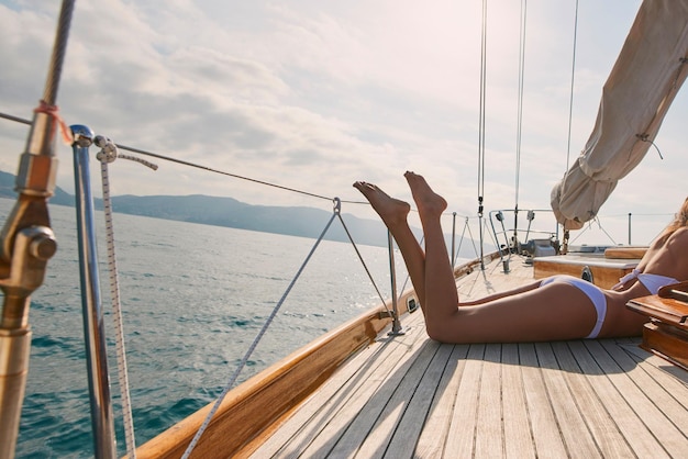 Benen van sexy vrouw in witte bikini liggend op boot zonnebaden Vrouw in witte bikini looien benen op een boot Sexy benen van vrouw dragen witte bikini zonnebaden op een cruise