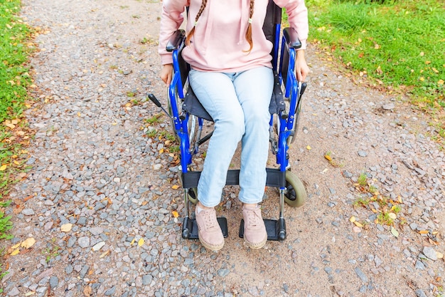 Benen voeten handicap vrouw in rolstoel wiel op weg in ziekenhuis park wachten op patiëntendiensten