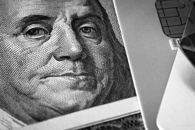 Foto benjamin franklin faccia su una banconota da cento dollari accanto a una carta di credito