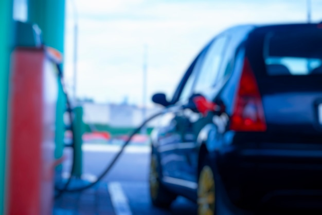 Benzinestation bij nacht. De auto rijdt op benzine. Wazige foto voor achtergrond.