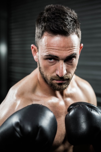 Bepaalde shirtloze man met bokshandschoenen bij de Crossfit-sportschool