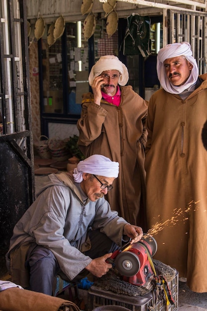 Berber men dressed in traditional clothes sharpening knife on the market in Djelfa, Algeria