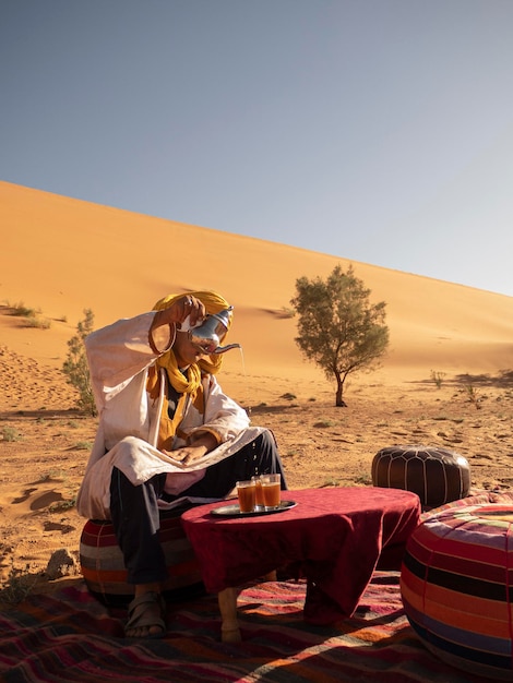 Photo berber in the sahara desert serving a cup of tea