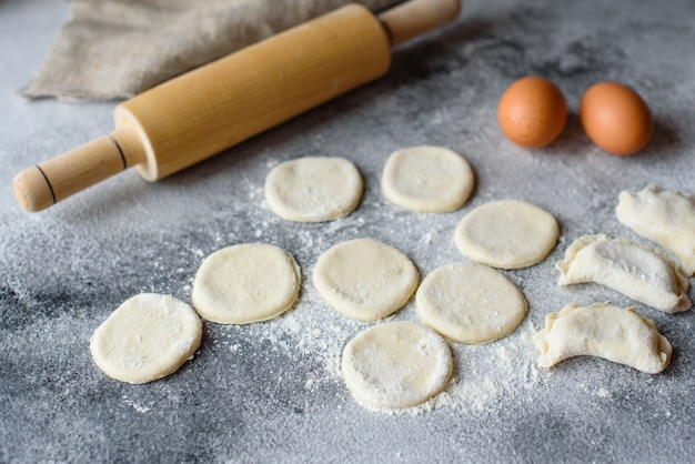 Bereid deeg en productie van cirkels uit deeg voor de bereiding van dumplings met een vulling. Het kan als achtergrond worden gebruikt