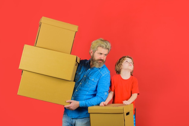 Bereid je voor op het verplaatsen van verpakkingsdingen vader en zoon met dozen familieconcept gelukkig zoontje en