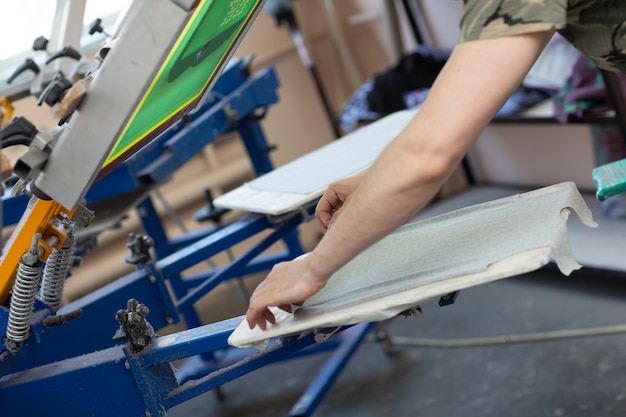 Bereid u voor op het afdrukken en pas het zeefdrukproces van de doekzeefdruk toe in de kledingfabriek.