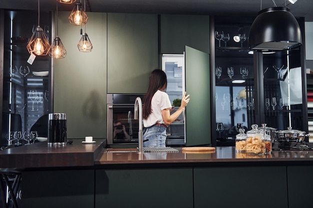 Bereiden van vers voedsel Jonge mooie brunette in vrijetijdskleding binnenshuis in de keuken overdag