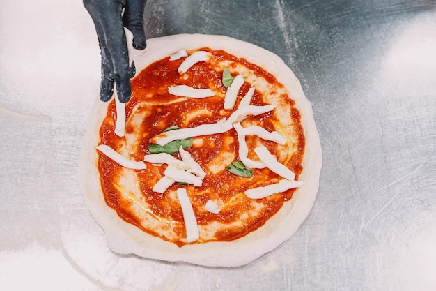 Bereiding van een huisgemaakte italiaanse pizza door een specialist