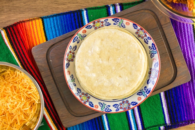 Bereiding van kip enchiladas met cheddar kaas en saus.