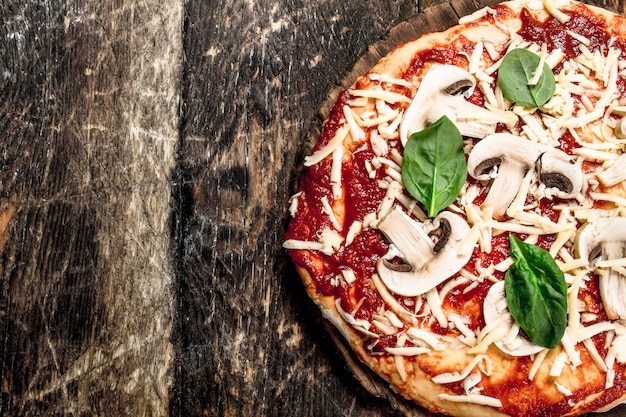 Foto bereiding van pizza met natuurlijke ingrediënten. op een houten achtergrond.